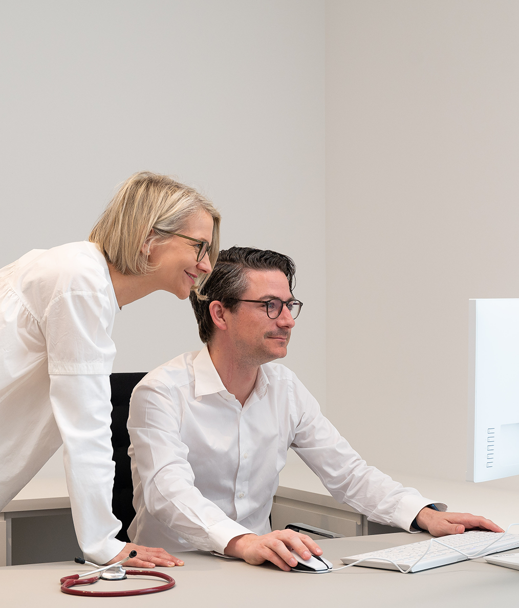 Dr. Karoline Horvatits & Dr. Thomas Horvatits bei der Arbeit vor dem PC in der Arztpraxis